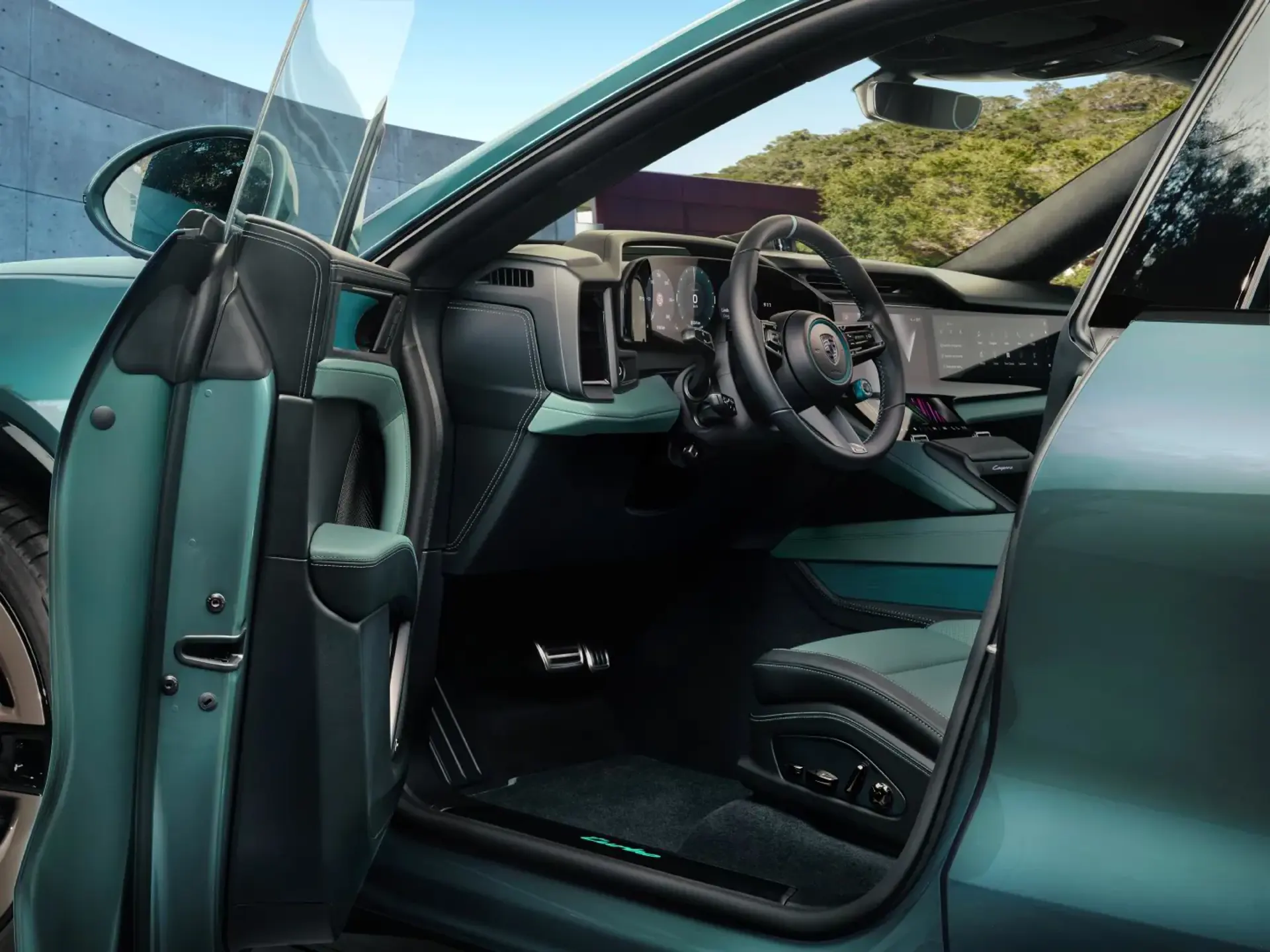 Åben førerdør, der viser det moderne, turkisfarvede interiør og cockpit i en Porsche Cayenne Electric.