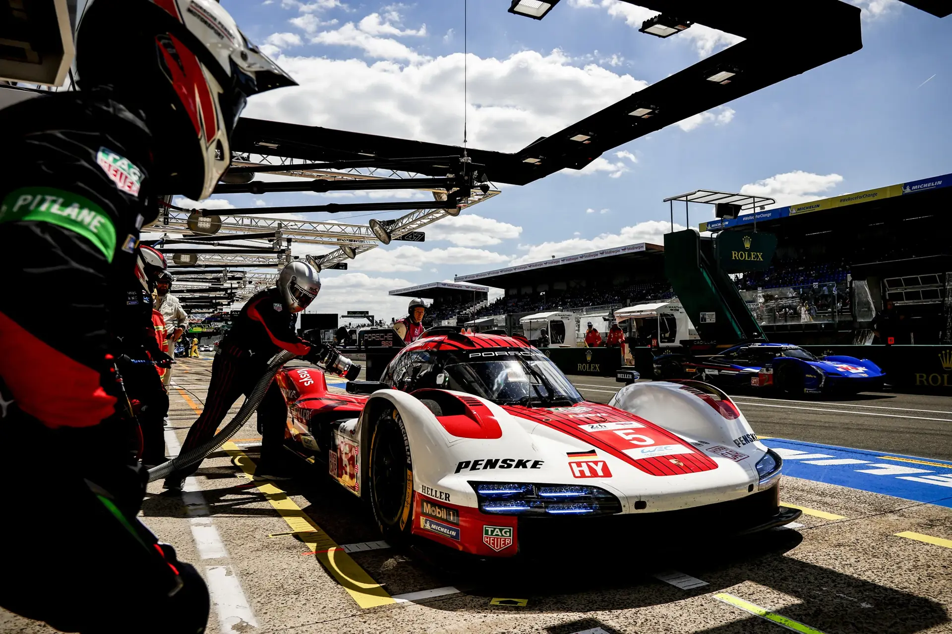Racerbil fra Penske Porsche får service i pitten under et motorsportsløb på banen.