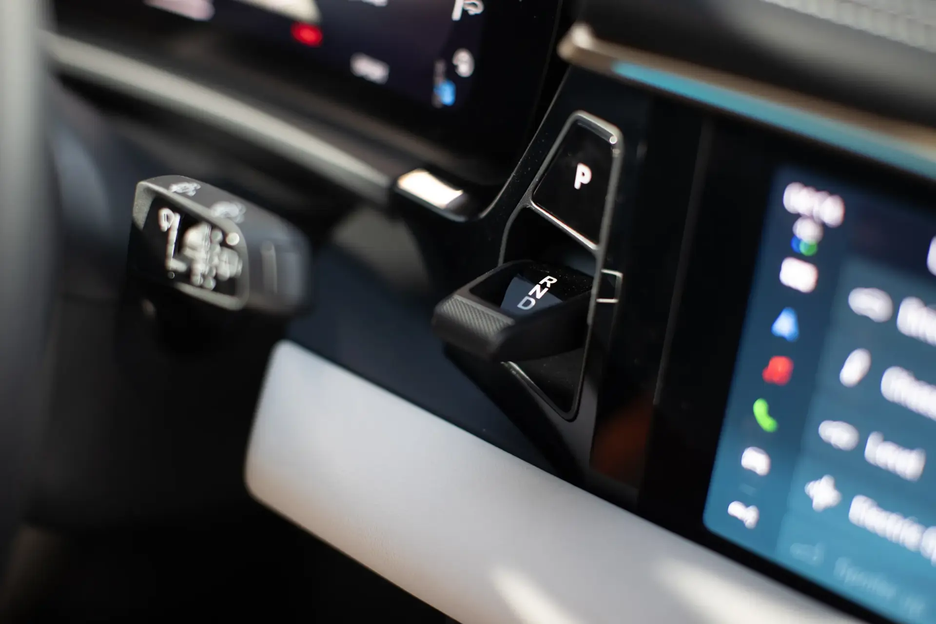 Nærbillede af et moderne bilinstrumentbræt med gearvælger og digitalt display.