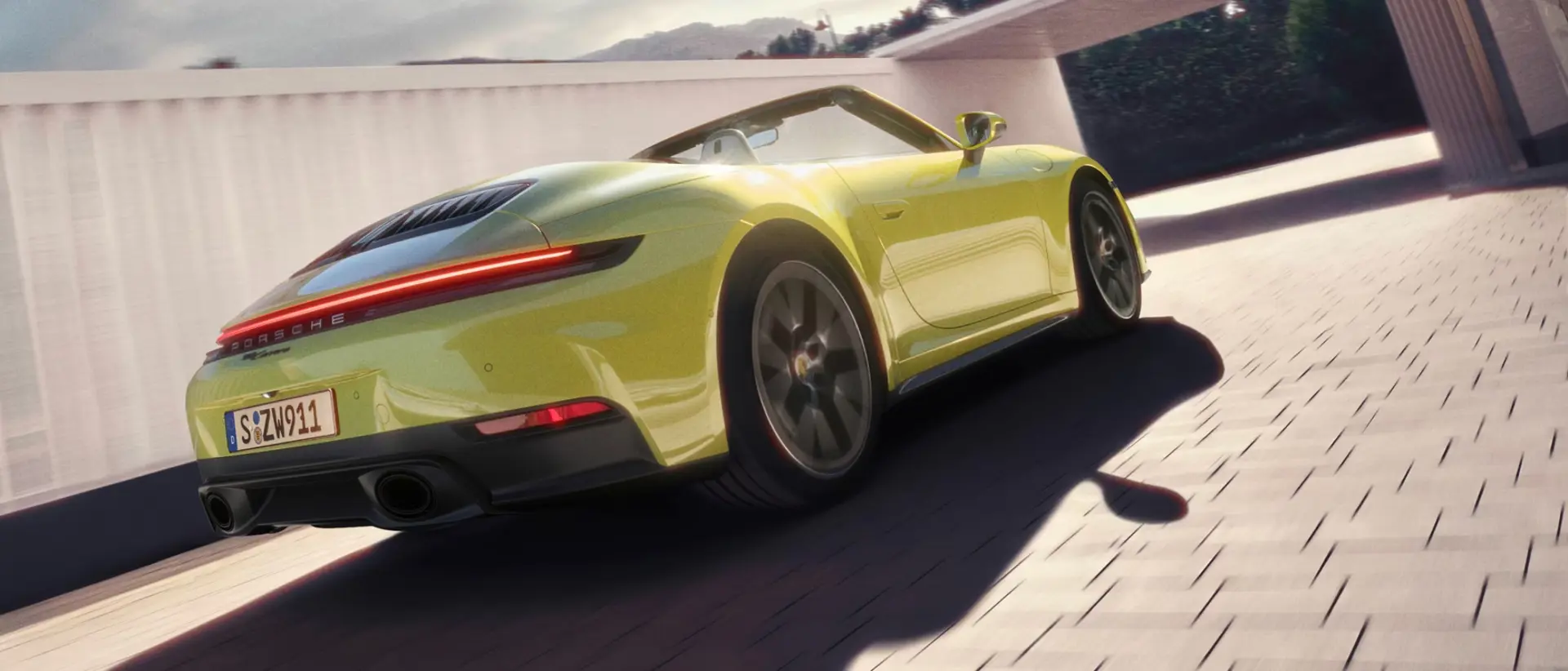 Gul cabriolet-Porsche set bagfra i fart gennem en lys, moderne tunnel.
